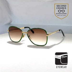 Könnte beinhalten: Sonnenbrille mit goldenem Rahmen, grünen Rändern und braunen Farbverlaufsgläsern. Die Bügel sind goldfarben mit schwarzen Spitzen. Das Bild enthält den Text "SECOND CHANCE EYEWEAR" und "AUTHENTICATORS VERIFY THE VISION".