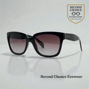 May include: Black sunglasses with a gradient lens. The sunglasses have a thick frame and the brand name "Prada" is visible on the temple. The image includes the text "Second Chance Eyewear" and a logo that says "Second Chance Authenticator Verify the Vision."