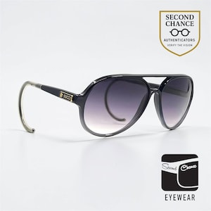 Könnte beinhalten: Schwarze Aviator-Sonnenbrille mit Farbverlaufgläsern. Die Sonnenbrille hat einen Doppelsteg und ein goldfarbenes Logo am Bügel. Der Rahmen ist schwarz mit silberfarbenen Bügeln. Der Text "Second Chance Eyewear" ist enthalten.