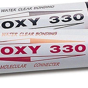 May include: Two tubes of Epoxy 330 water clear bonding adhesive. One tube has a black cap, the other a white cap. The tubes are silver with red and black text. The text includes "Molecular Connecter" and "Conforms To ASTM D4236".