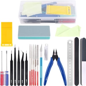 May include: A comprehensive electronics repair kit featuring a clear plastic storage box, screwdrivers, tweezers, files, a ruler, and a blue-handled wire cutter. Includes a yellow plastic tool and a gray sanding block. The kit is designed for detailed work.