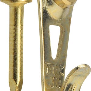 May include: A close-up of a gold-colored picture hanging kit, including a nail and a hook. The nail has a rounded head and a pointed tip. The hook has a curved design with a hole for hanging and the number "30" stamped on it.