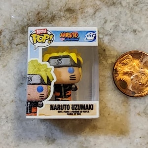May include: A miniature Naruto Uzumaki vinyl figure in a clear display box, next to a penny. The figure has yellow hair, a black headband, and an orange and black outfit. The box reads "Bitty Pop! Naruto Uzumaki".