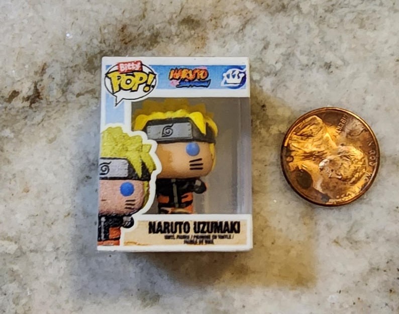 May include: A miniature Naruto Uzumaki vinyl figure in a clear display box, next to a penny. The figure has yellow hair, a black headband, and an orange and black outfit. The box reads "Bitty Pop! Naruto Uzumaki".