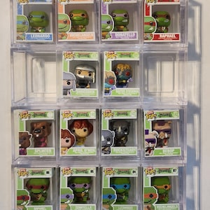 May include: A collection of Teenage Mutant Ninja Turtles Funko Pop! figures in clear display cases. The figures include Leonardo, Michelangelo, Donatello, Raphael, Shredder, Baxter Stockman, Splinter, April O'Neil, Rocksteady, and Bebop.