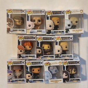 May include: A collection of 10 Harry Potter Pop! Vinyl figures in their original packaging. The figures include Harry Potter, Dobby, Draco Malfoy, Lord Voldemort, Ron Weasley, Rubeus Hagrid, Albus Dumbledore, Minerva McGonagall, Nearly Headless Nick, and Bellatrix Lestrange.