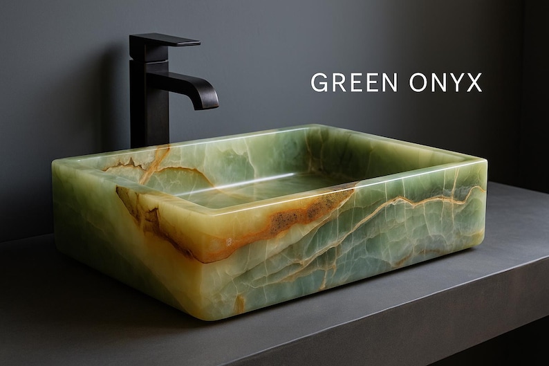 May include: A rectangular green onyx sink with a black faucet. The sink has a natural, veined pattern with shades of green, brown, and yellow. The text "GREEN ONYX" is displayed on the image. This sink is a bathroom fixture.