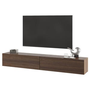 Op de afbeelding: Een moderne, zwevende tv-meubel in een donkerbruine afwerking, met twee lades. Een grote, zwarte flatscreen-tv is erboven gemonteerd. Decoratieve items zijn een kleine, transparante doos, een zilveren sculptuur en twee kleine glazen.