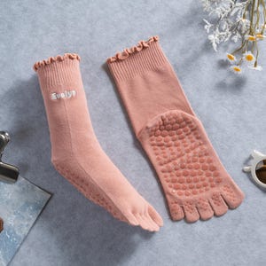 May include: A white ceramic mug with a black handle and the text "But First, Coffee" in a black, handwritten-style font. The mug is on a white surface.