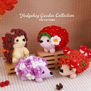 Pode incluir: Quatro figuras de ouriços de crochê do padrão PDF Hedgehog Garden Collection. Um tem espinhos castanhos, um é coberto com texturas vermelhas tipo morango com uma flor branca, um é roxo e branco e um tem detalhes de cogumelos vermelhos.
