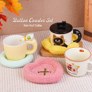 May include: A collection of mugs and coasters. The mugs are decorated with a duck, a cat, and a bear. The coasters are crocheted in pastel colors, including pink, green, and yellow. The text "Button Coaster Set PDF Pattern" is visible.