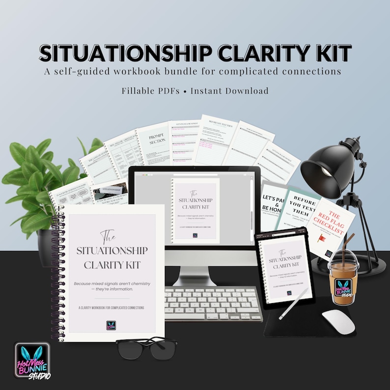 May include: A workspace setup featuring a workbook titled "The Situationship Clarity Kit" with the text "Because mixed signals aren't chemistry - they're information." Also includes a computer, tablet, and books.
