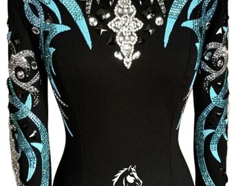 May include: Black equestrian show jacket with turquoise and silver embellishments. The jacket features intricate designs on the sleeves and collar, with a central crystal-like pattern. The text "HIDE HAVEN SADDLERY" is displayed on the lower part of the jacket.