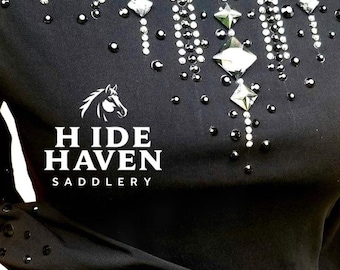 May include: Black equestrian show shirt with sparkling crystal and rhinestone embellishments. The shirt features a classic collar and long sleeves, with the "Hide Haven Saddlery" logo in white.