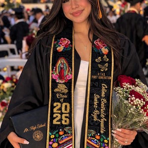 May include: A graduate in a black cap and gown, holding a diploma and a bouquet of red roses. The graduation sash is black with gold trim, floral accents, and the text "Class of 2025".