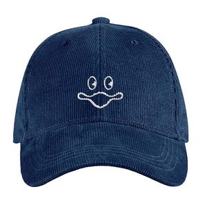 Könnte beinhalten: Marineblaue Cord-Baseballkappe mit weiß gesticktem Cartoon-Gesicht. Die Kappe hat einen gebogenen Schirm und einen Knopf oben. Der Hut ist ein klassisches Sechs-Panel-Design.