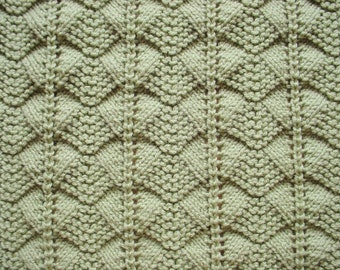 Manta de bebé tejida a mano en color verde salvia claro, ideal como regalo unisex para baby shower.