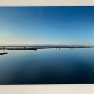 Stunning seascape photo of a calm West Kirby lake on the Wirral with the sea behind in blues