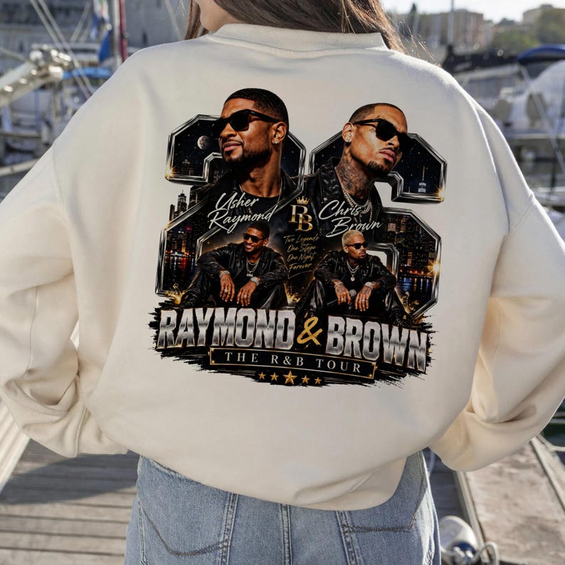 Back view of a person wearing a beige hoodie that displays the high-resolution Usher and Chris Brown 2026 concert tour design with sharp, contrasting metallic gold details.