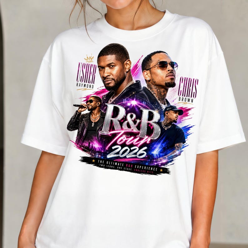 May include: A white short-sleeve t-shirt featuring a graphic print of Usher and Chris Brown. The design includes the text R&B Tour 2026, Usher Raymond, and Chris Brown, with colorful brushstroke accents in pink, purple, and blue surrounding the artists.