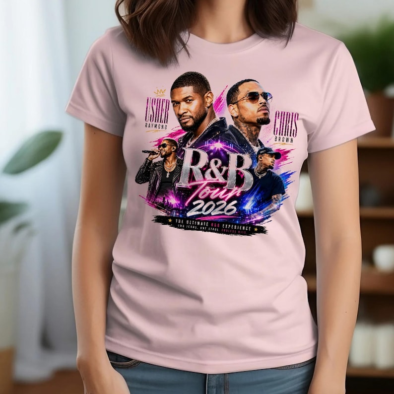 May include: A light pink t-shirt featuring a graphic print of musical artists Usher and Chris Brown. The design includes the text R&B TOUR 2026, Usher Raymond, and Chris Brown, set against a vibrant background of blue and pink light streaks.