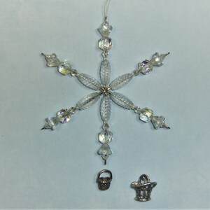 May include: A clear crystal snowflake ornament with a silver wire hanger and two small silver baskets.