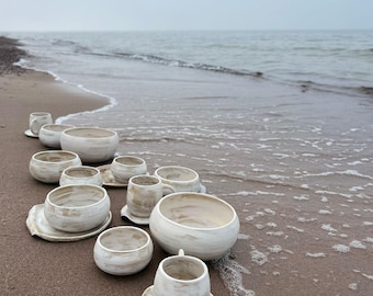 set of white ceramic bowls, cups with saucers