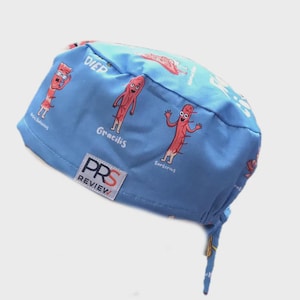 Könnte beinhalten: Eine hellblaue OP-Haube mit Cartoon-Illustrationen von Muskeln und Beschriftungen wie "DIEP" und "Gracilis". Die Haube trägt auch den Text "PRS REVIEW" auf einem weißen Etikett.