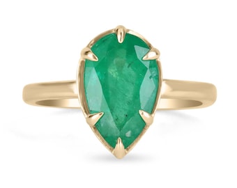 Puede incluir: Un anillo de oro con una piedra preciosa de esmeralda en forma de pera. La esmeralda es de un color verde vibrante y tiene un corte facetado.