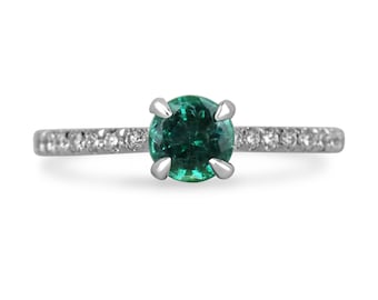 May include: A silver ring featuring a round green emerald gemstone and a band of small diamonds.
