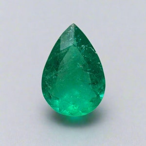 May include: A pear-shaped emerald gemstone with a deep green color. The gemstone is faceted and has a high degree of clarity.