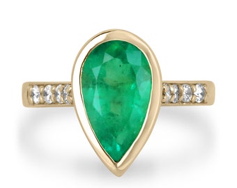 Puede incluir: Un anillo de oro amarillo con una esmeralda de forma de pera y una banda de pequeños diamantes.