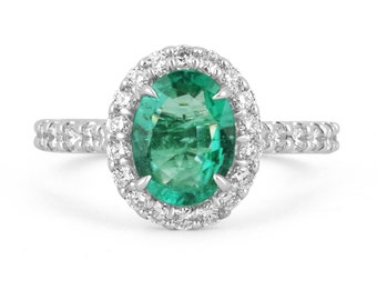 Anillo de compromiso de oro blanco de 14 quilates con halo de diamantes y esmeralda ovalada extraída de la tierra en un verde eléctrico intenso de 2,20 quilates. Anillo de aniversario de oro blanco con halo de diamantes y esmeralda ovalada de 14 quilates.