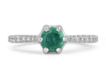 May include: A silver ring featuring a green emerald gemstone and a band adorned with small diamonds.