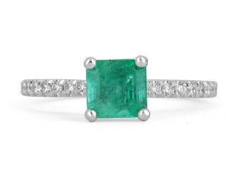 May include: A square emerald gemstone ring with a pave diamond band. The ring is set in white gold.