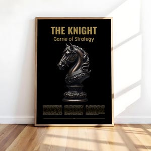 May include: A framed poster featuring a bronze-colored chess knight piece on a black background. The text "THE KNIGHT Game of Strategy" is displayed in gold at the top. The poster is displayed on a wooden floor.
