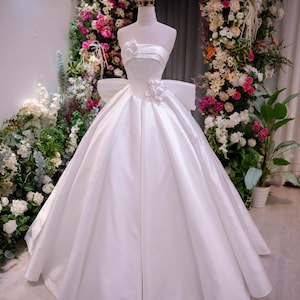 Elegant White Satin Ball Gown Wedding Dress, Strapless with 3D Floral Appliqué, Bow Back Detail, Princess Bridal Gown