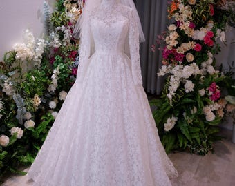 Elegant lace bridal gown with long sleeves and high neck, Off shoulder floral design with train and veil, ideal for church or garden wedding