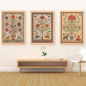May include: Three framed art prints with colorful, intricate tree and animal designs. The artwork features a cream background with red, blue, yellow, and green details. The frames are a light wood color, and the overall style is reminiscent of traditional Indian art.