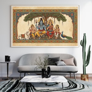 Puede incluir: Una obra de arte enmarcada y colorida que representa a una familia bajo un &aacute;rbol. La obra presenta figuras con vestimenta tradicional, una vaca y un pavo real. El marco tiene un borde decorativo con patrones florales y geom&eacute;tricos. La obra se exhibe sobre un sof&aacute; gris.
