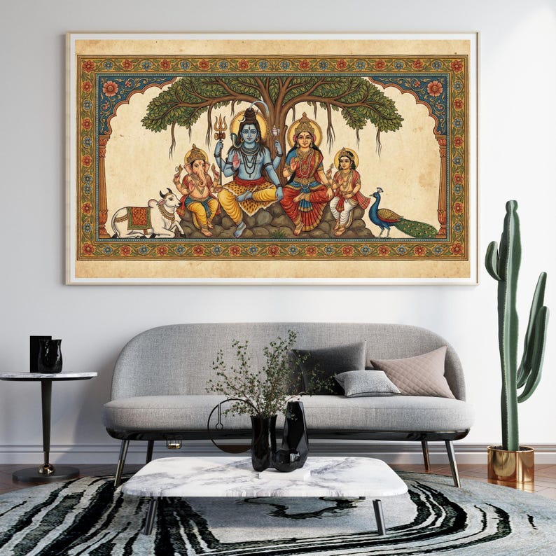 Puede incluir: Una obra de arte enmarcada y colorida que representa a una familia bajo un &aacute;rbol. La obra presenta figuras con vestimenta tradicional, una vaca y un pavo real. El marco tiene un borde decorativo con patrones florales y geom&eacute;tricos. La obra se exhibe sobre un sof&aacute; gris.