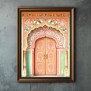 May include: A framed print depicting an elaborately decorated doorway. The door is a soft peach colour with floral carvings. The archway and frame feature intricate floral patterns in pink, orange, and green. The frame is a dark brown.