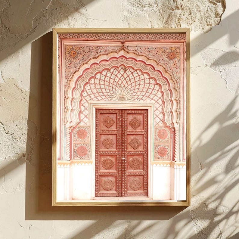 May include: Framed print of an ornate, arched doorway with intricate carvings and a double door. The color palette features shades of red, pink, and gold, creating a warm and inviting aesthetic. The artwork is set against a neutral background.