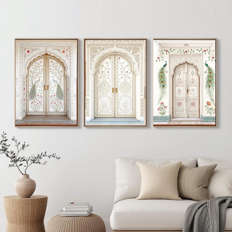 May include: Set of three framed art prints featuring ornate white doors with intricate carvings. The artwork includes peacock and floral motifs in soft colors, set against a neutral background. The frames are a warm, natural wood tone.