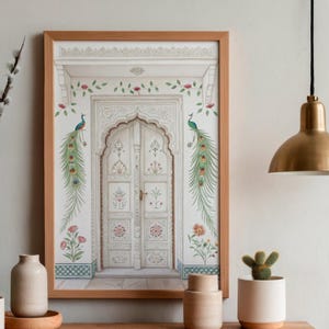 May include: A framed print featuring a detailed illustration of a white arched doorway with intricate carvings. Two peacocks with long, colorful tail feathers flank the door. Floral and vine accents in pink and green adorn the frame, creating an elegant aesthetic.
