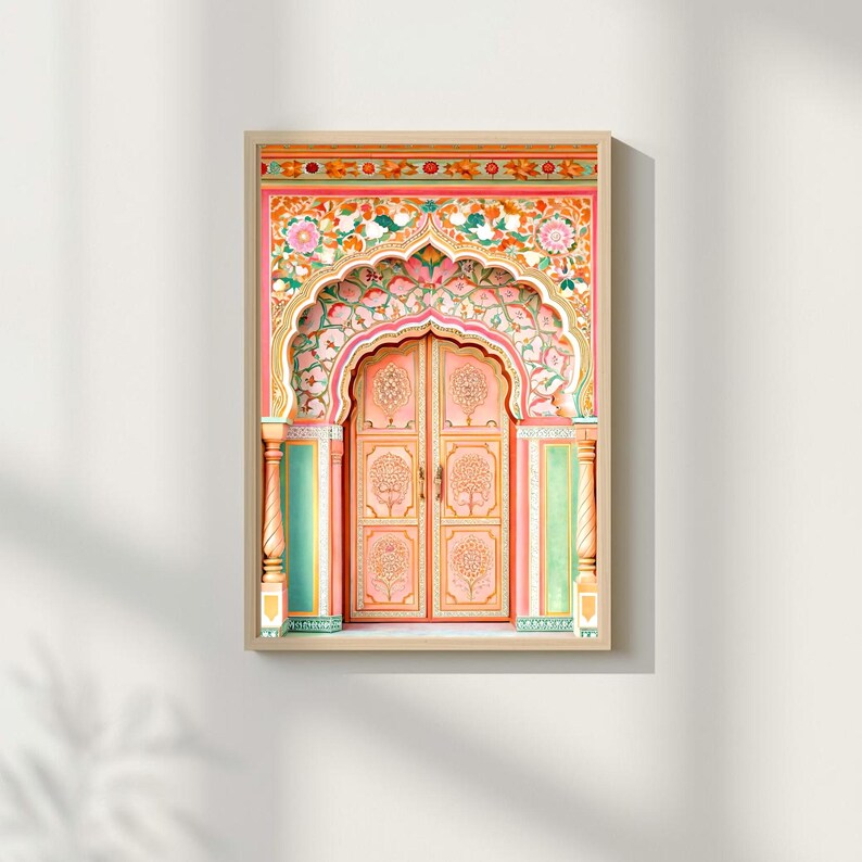 May include: A framed print featuring a detailed, ornate archway and door. The archway is pink with floral and leaf patterns in pink, green, and white. The door is a soft pink with tree designs. The frame is a light wood colour.