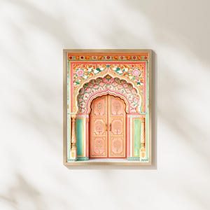 May include: A framed print depicting a detailed illustration of an ornate, arched doorway. The door is painted in shades of pink and peach, with intricate floral and tree designs. The frame is a light wood colour, set against a white background.