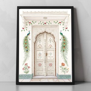 May include: A framed art print featuring a white arched doorway with intricate carvings. The artwork includes colorful floral and peacock feather accents, with two peacocks perched on the wall. The print is set against a white wall with a black frame.