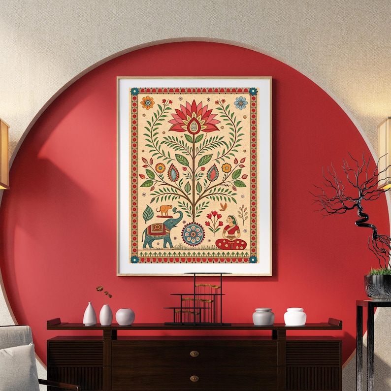 May include: A framed, colorful Indian folk art print. The artwork features a central tree design with a large lotus flower at the top. The tree is adorned with leaves, flowers, and animals, including an elephant. A woman in red sits at the base.