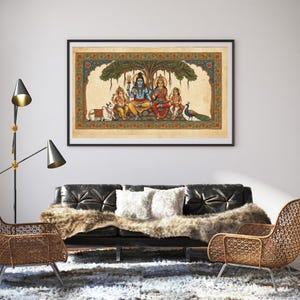 Puede incluir: Una pintura hind&uacute; enmarcada y colorida representa a una familia bajo un &aacute;rbol. La obra presenta figuras con ropa vibrante, una vaca y un pavo real. La pintura se exhibe sobre un sof&aacute; de cuero negro con una manta de piel sint&eacute;tica.